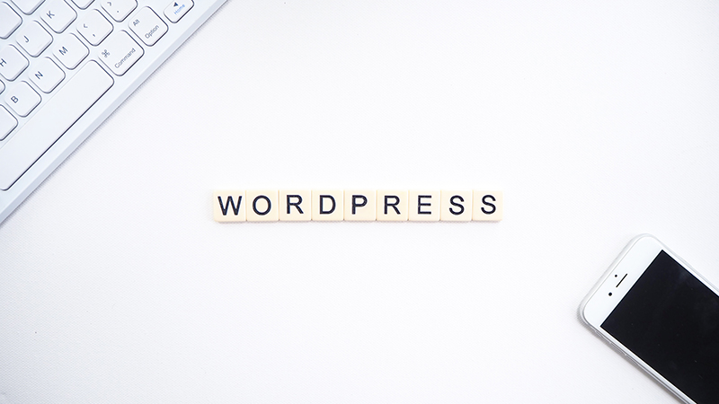 WordPress text near a keyboard and a mobile phone.